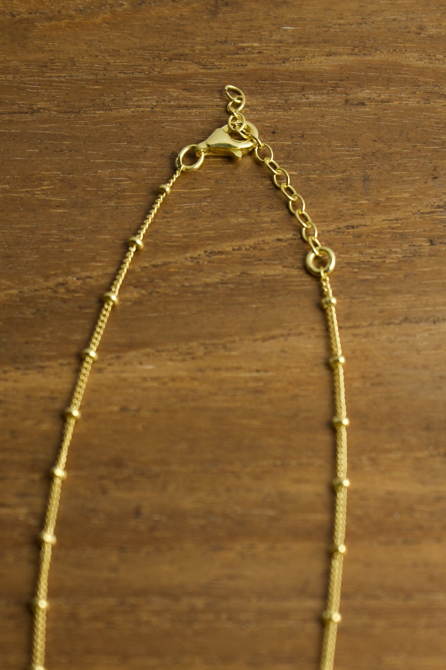 Gold necklace on a wooden surface