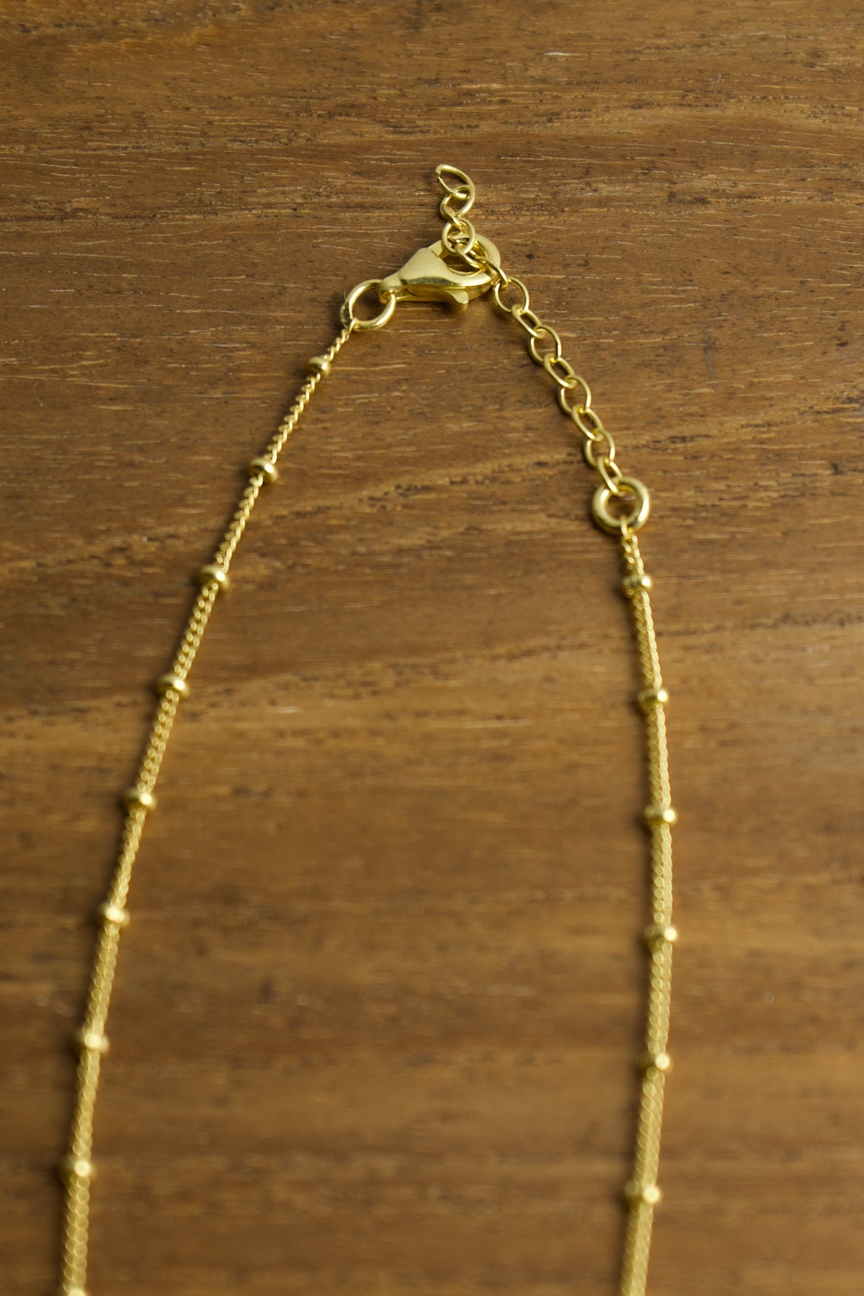 Gold necklace on a wooden surface